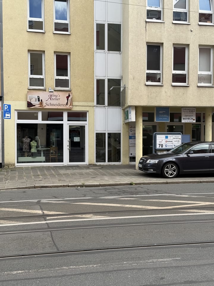 Schaufenster des Ateliers mit Ladenschild „Alina's Atelier Schneiderei“